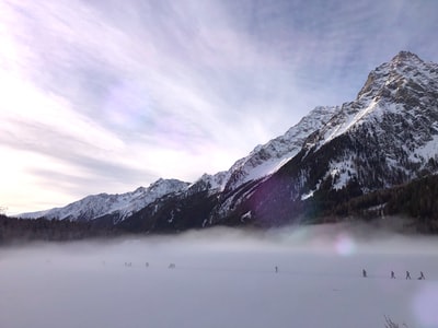 人们徒步旅行期间在积雪覆盖的冰川附近山上的一天
